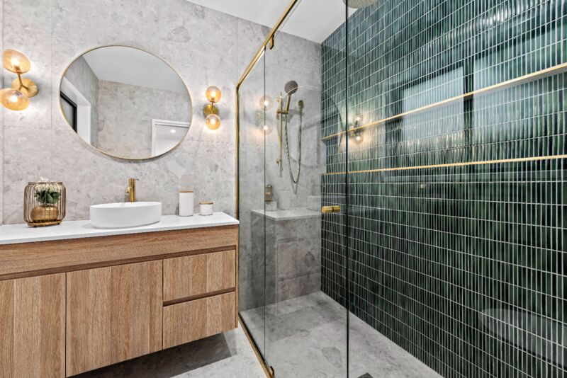 Emerald-tile ensuite with brass fixtures